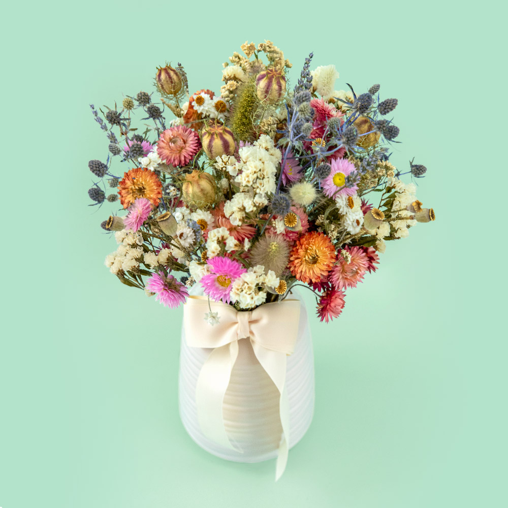 Blush pastel dried flower bouquet with pink, white, blue and orange preserved blooms, including strawflowers, statice, nigella, bunny tails, sea holly and seed pods. Perfect for a vase and home décor