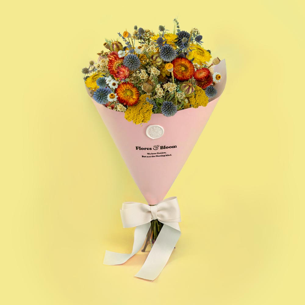 Farmhouse dried flower bouquet featuring colourful blooms in orange, yellow, blue and white tones agains a soft yellow background, ideal for a thinking of you gift